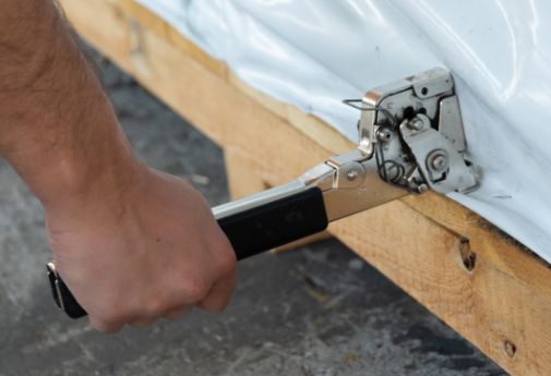 DEUFOL-Mitarbeiter befestigt Verpackungsmaterial an Kistenboden