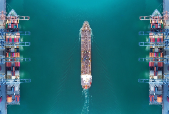 Schiff fährt durch Hafen mit Kränen