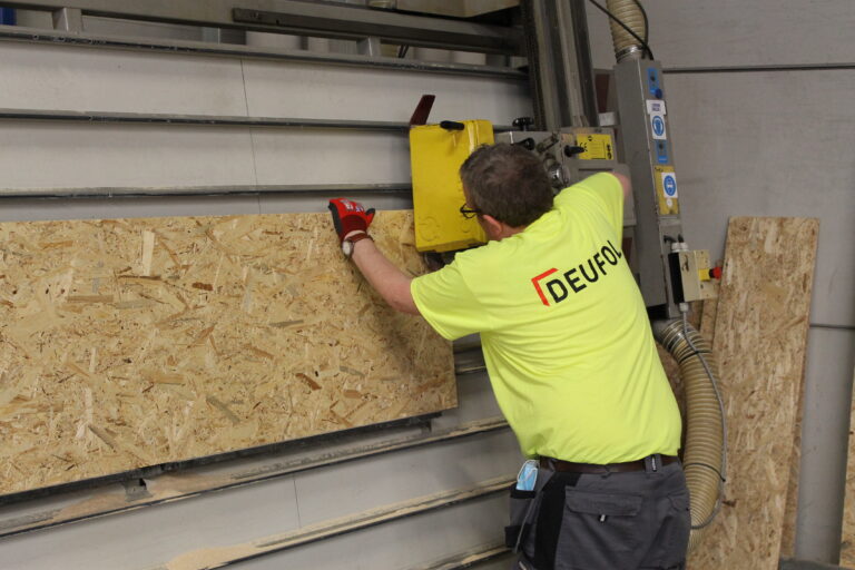 Eine Seefrachtkiste und Seefrachtverpackung wird von einem DEUFOL-Mitarbeiter mit einer Machine gefertigt.
