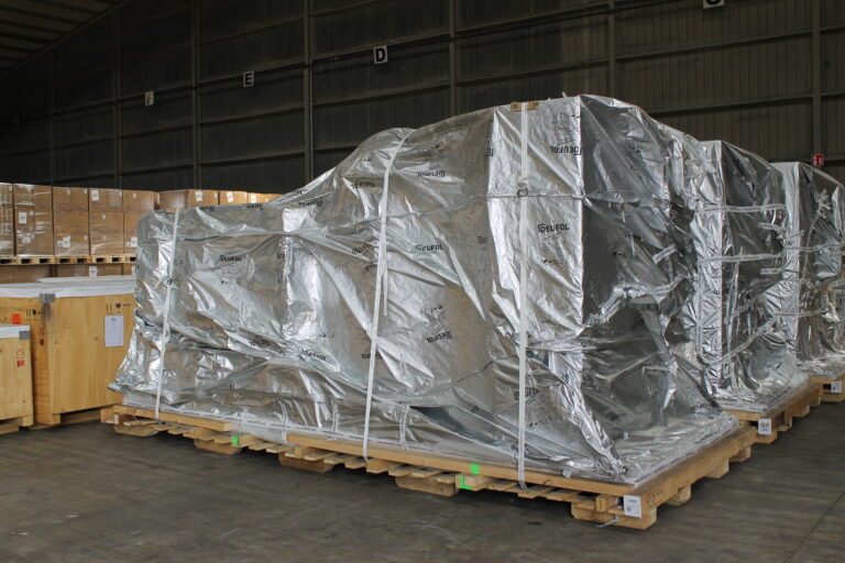 Ware in Seefrachtverpackung verpackt und auf einer Palette gespannt.